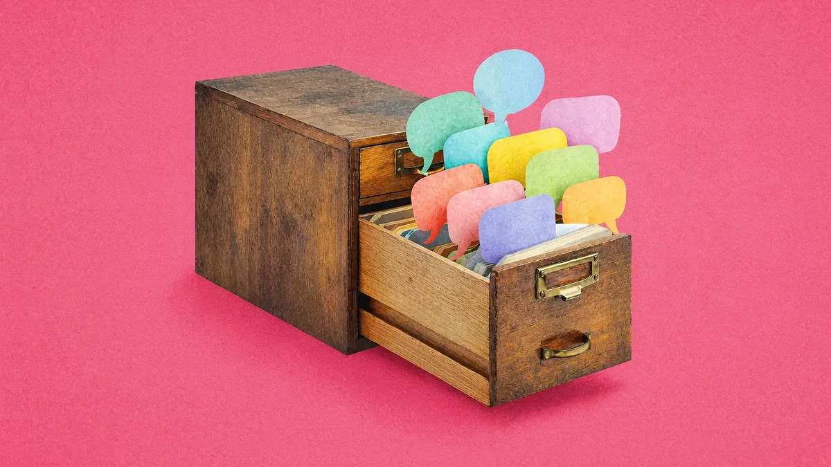 A wooden filing cabinet with the top drawer open and multicoloured speech bubbles spilling out, on a textured pink background