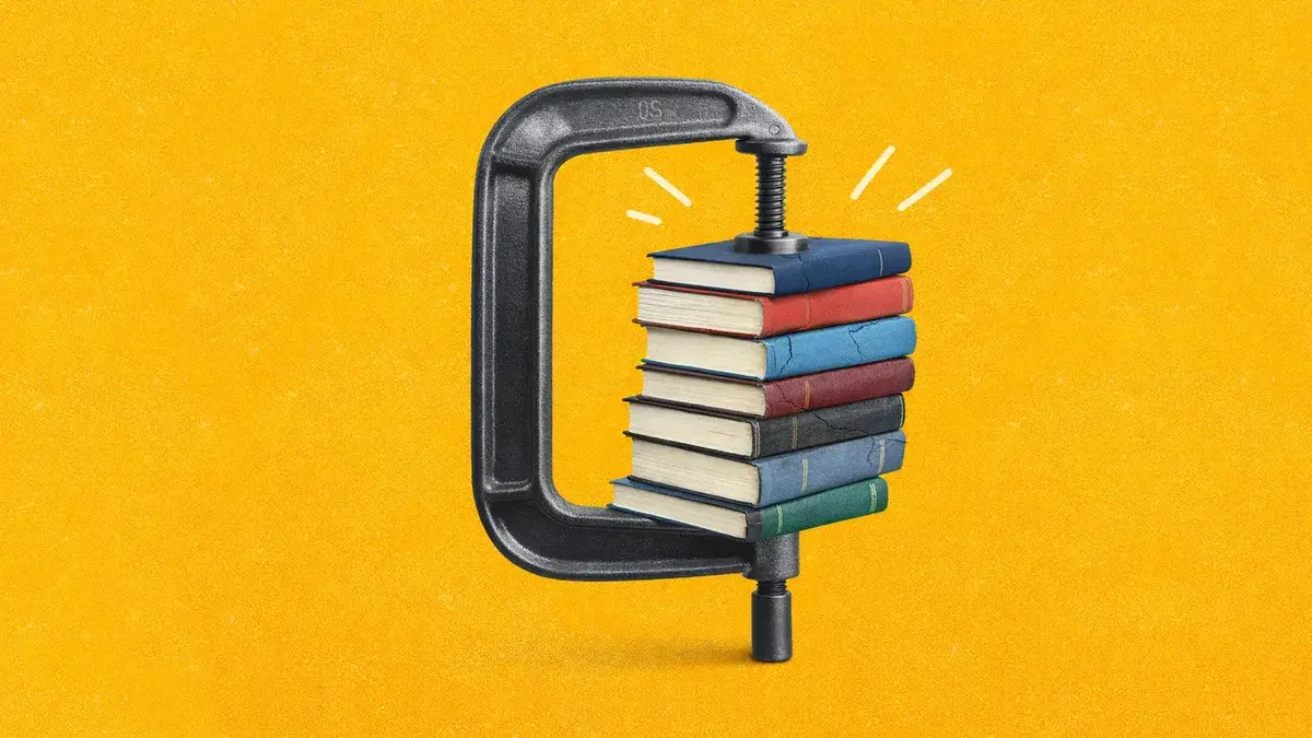A stack of multicoloured books squeezed in a metal C-clamp on a textured yellow background