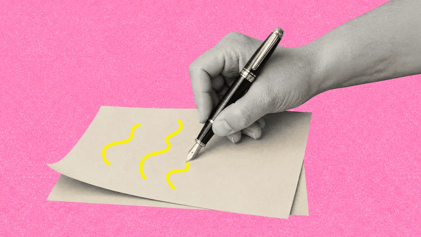 A hand holding a fountain pen drawing squiggles on a sheet of paper, on a pink background